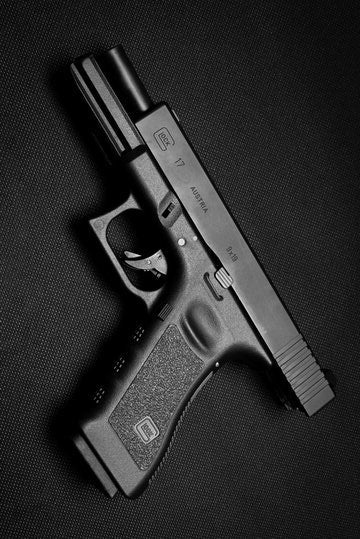 Matte black pistol lighter on a dark surface